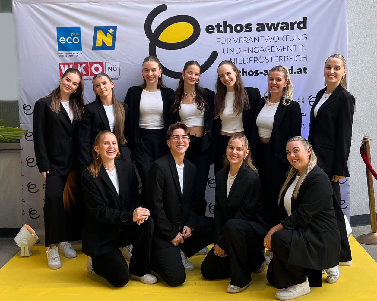 Teamfoto vor dem Ethos Award Plakat